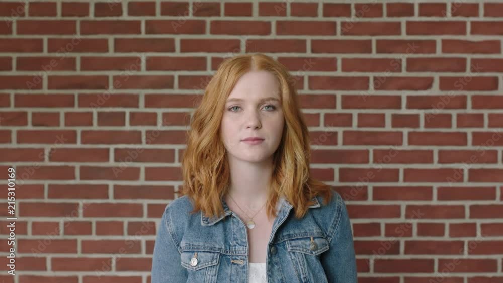 portrait of beautiful red head woman looking serious pensive on brick wall background portrait of beautiful red head woman looking serious pensive on brick wall background