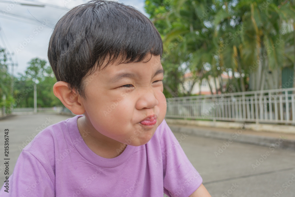 Asian boy with funny face on street. Asian boy with funny face on street.