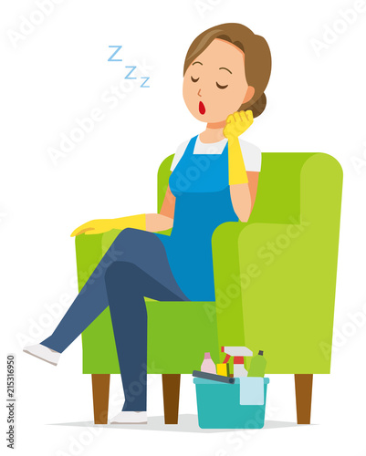 A woman wearing a blue apron and rubber gloves is falling asleep sitting on the sofa