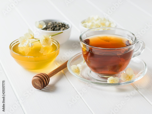 Honey, herbal tea and jasmine on a white wooden table. A set of natural products for the treatment of many diseases.