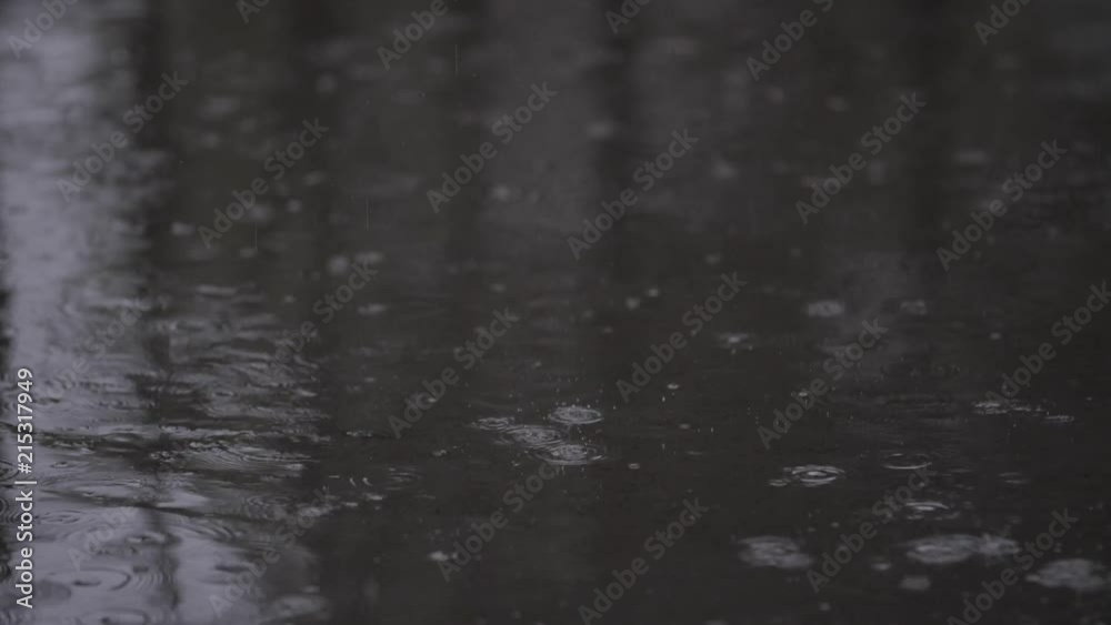 Water droplets fall and splatter on pavement in slow motion Water droplets fall and splatter on pavement in slow motion