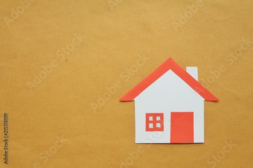 Paper cut of house red roof on brown background,top view. 