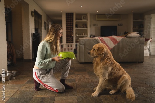 Girl feeding her dog at home