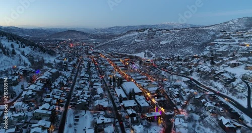 Aerial drone shot quickly descends while flying backwards over main street in Park City at dusk during winter SUNDANCE FILM FESTIVAL photo