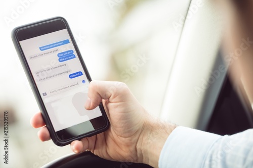Businessman using mobile phone in a car 