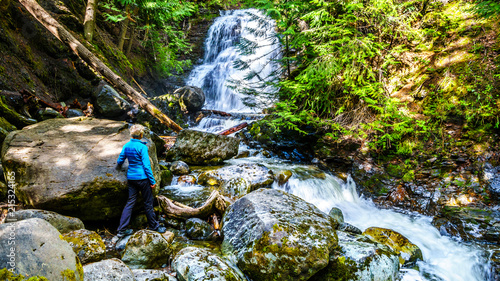 Senior Woman at Whitecroft Falls, a waterfall on McGillivray Creek and a short hike from Sun Peaks Road near the town of Whitecroft in the Shuswap region of the Okanagen in British Columbia, Canada photo