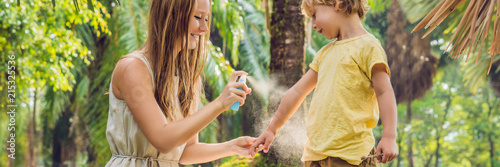 Mom and son use mosquito spray.Spraying insect repellent on skin outdoor BANNER, long format