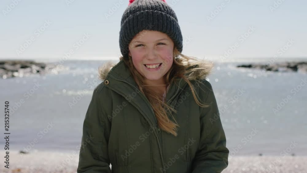 portrait of happy girl on beach smiling cheerful dressed warm wearing beanie hat and coat portrait of happy girl on beach smiling cheerful dressed warm wearing beanie hat and coat