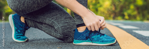 Female runner tying her shoes preparing for jogging outside .Young girld runner getting ready for training. Sport lifestyle BANNER, long format photo