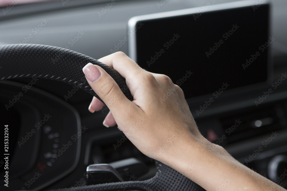 The hand of a girl with a stylish manicure lies on the handlebars in a saloon car. The hand of a girl with a stylish manicure lies on the handlebars in a saloon car.