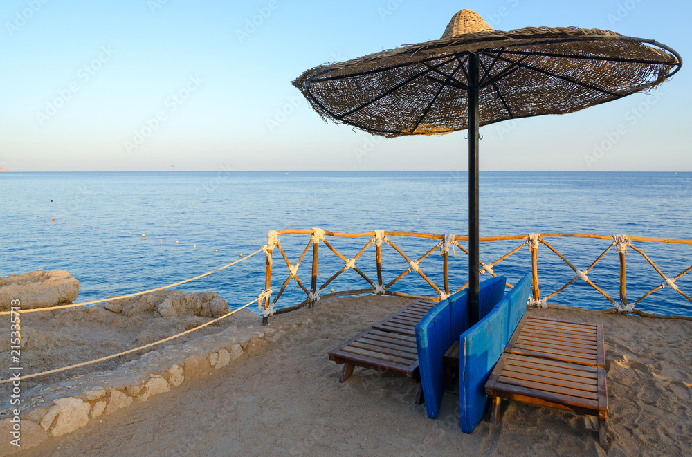Beach umbrella on rocky shore of Red Sea, Sharm El Sheikh, Egypt Beach umbrella on rocky shore of Red Sea, Sharm El Sheikh, Egypt