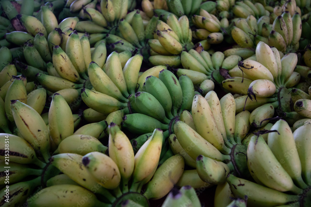 cluster of bananas type of tropical fresh fruits , heap of organic nutrition diet fruit at asian market in Thailand . common useful vitamin for good foods .