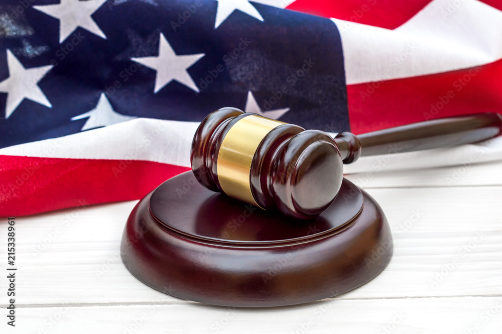 Judge's gavel with american flag on wooden background.