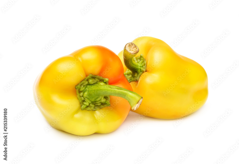 Two yellow sweet peppers on white.
