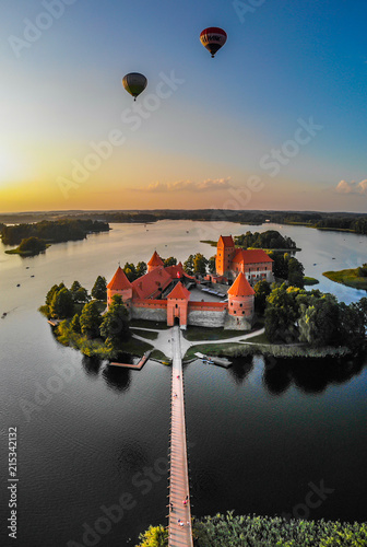 Trakai Island Castle with hot air balloons over it, located in Trakai, Lithuania on an island in Lake Galvė. 