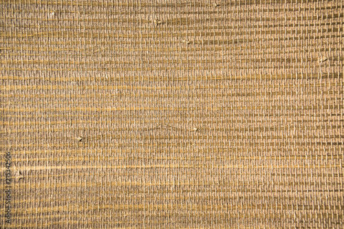 Closeup of a trendy straw wallpaper of ethnic style. Woven pattern background with bamboo and grass.