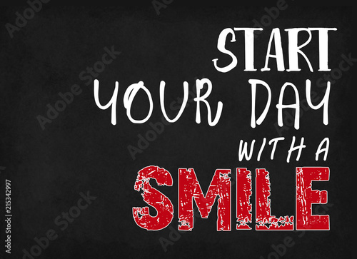 Start your day with a smile, words on blackboard background.