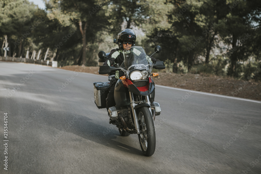 Fototapeta premium Mężczyzna jedzie na motocyklu turystycznym podczas wycieczki po górach.