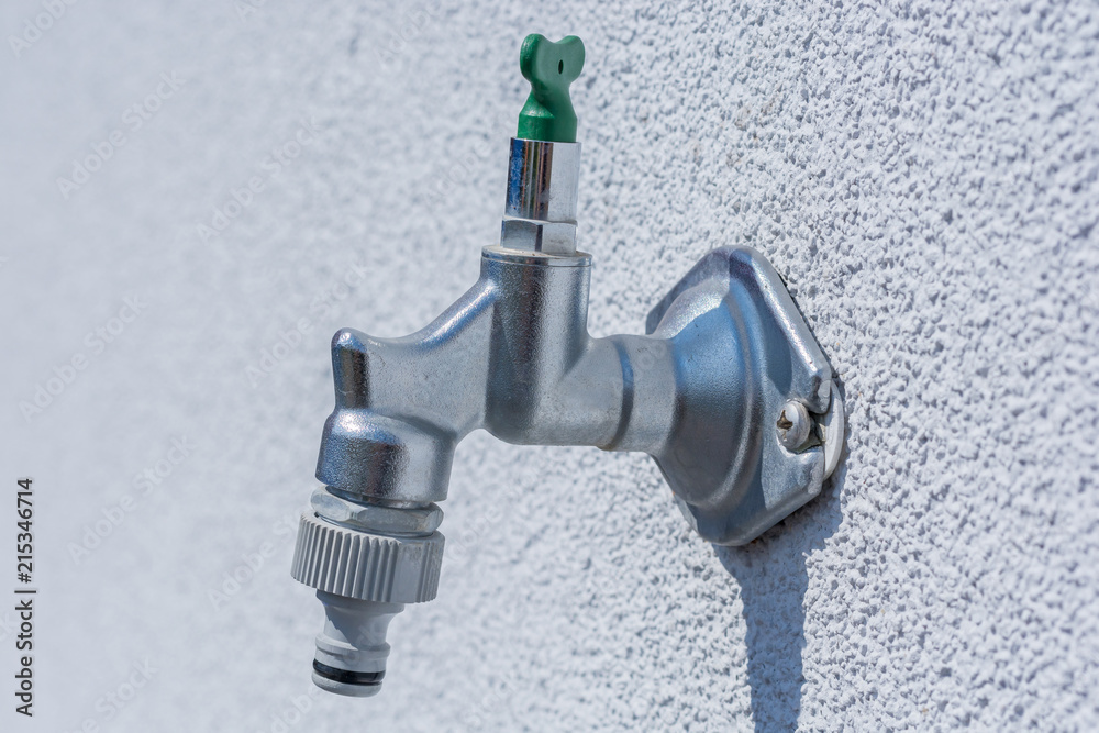 Wasserhahn an einer Hauswand mit Adapter für einen Gartenschlauch  Stock-Foto | Adobe Stock