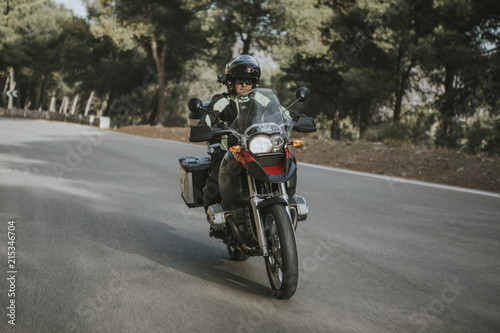 Man riding a touring motorbike during a trip across the mountains. © daviles