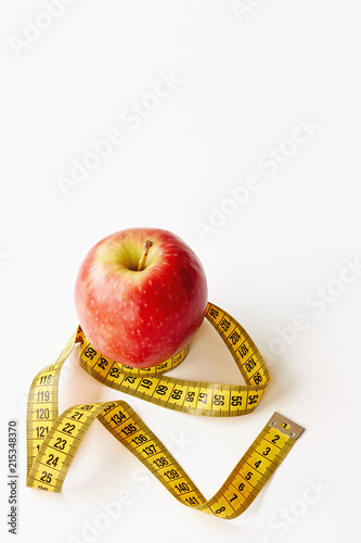 Measure tape and fresh fruit apple on white background. Loss weight, slim body, healthy diet concept