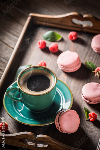 Black coffee and delicious pink macaroons served with hot coffee
