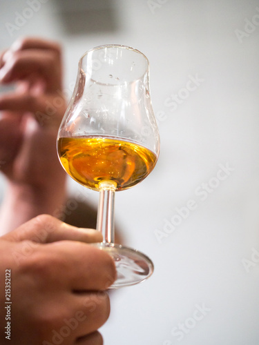 Hand holding a snifter glass filled with whisky