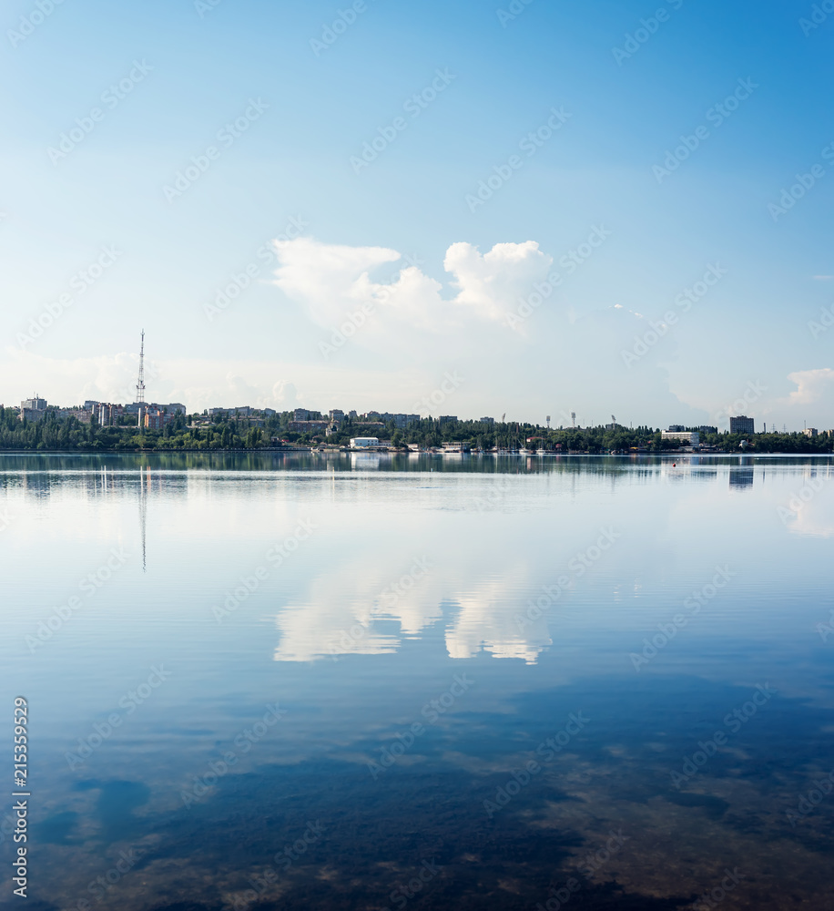 blue river and sky with clouds and reflections of it