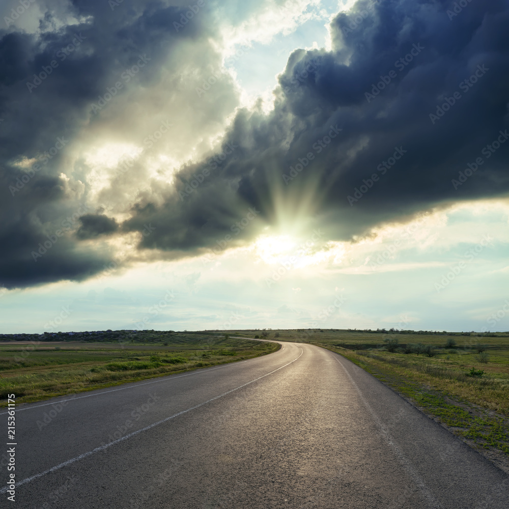 dramatic clouds in sunset over asphalt road