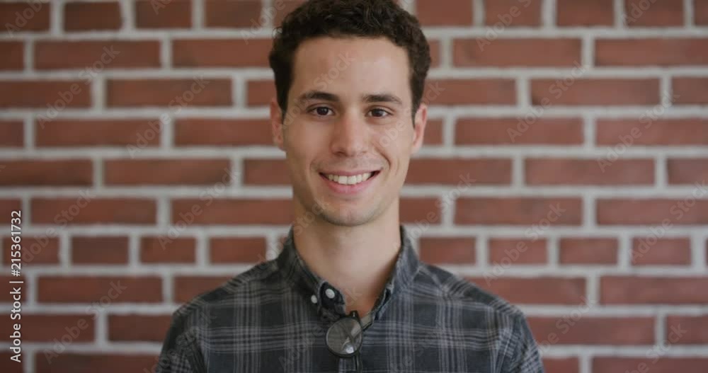 portrait attractive young hispanic man smiling enjoying successful lifestyle independent male satisfaction brick wall background portrait attractive young hispanic man smiling enjoying successful lifestyle independent male satisfaction brick wall background