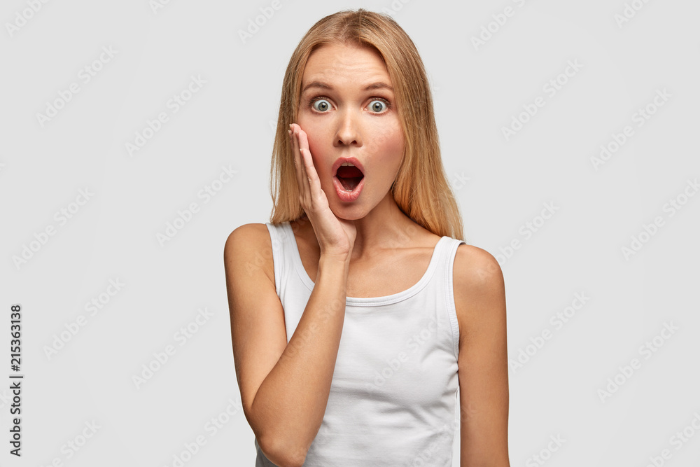 Portrait of beautiful young blonde shocked female gasps with opened Portrait of beautiful young blonde shocked female gasps with opened