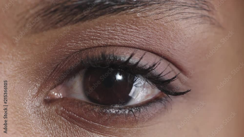 close up african american woman eye opening blinking looking at camera iris reflection 