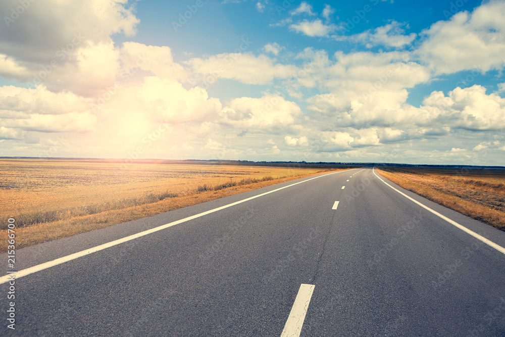 Beautiful and sunny road landscape with sky clouds and yellow fields