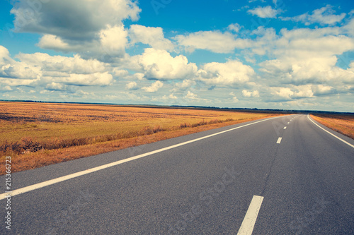 Beautiful and sunny road landscape with sky clouds and yellow fields