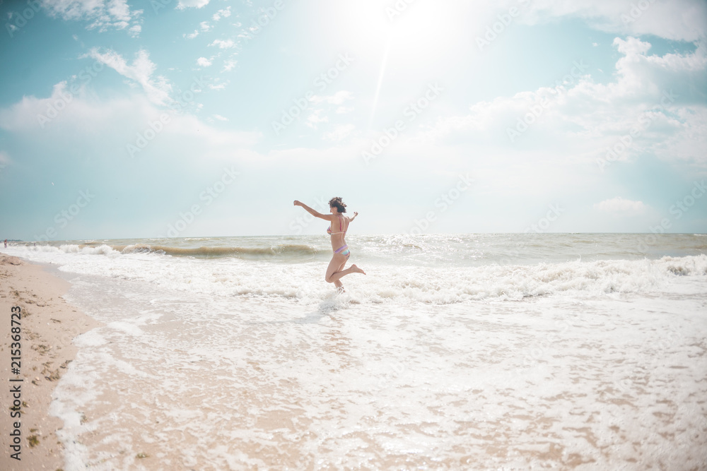 A girl is walking along the beach.