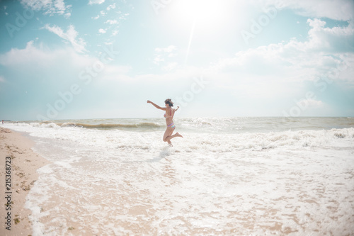 A girl is walking along the beach.