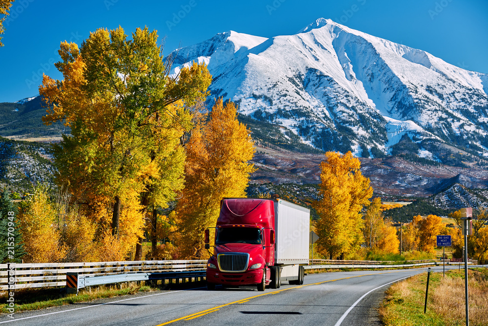 Naklejka premium Czerwona ciężarówka na autostradzie w Kolorado na jesieni