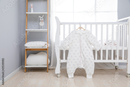 Simple, white baby bedroom with cot and rug photo