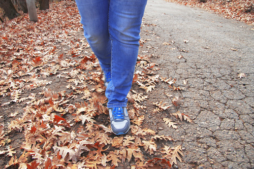 Young woman walking in autumn park close up