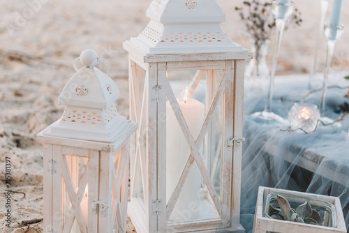 Big candles next to elegant table setup in blue pastels for a beach wedding