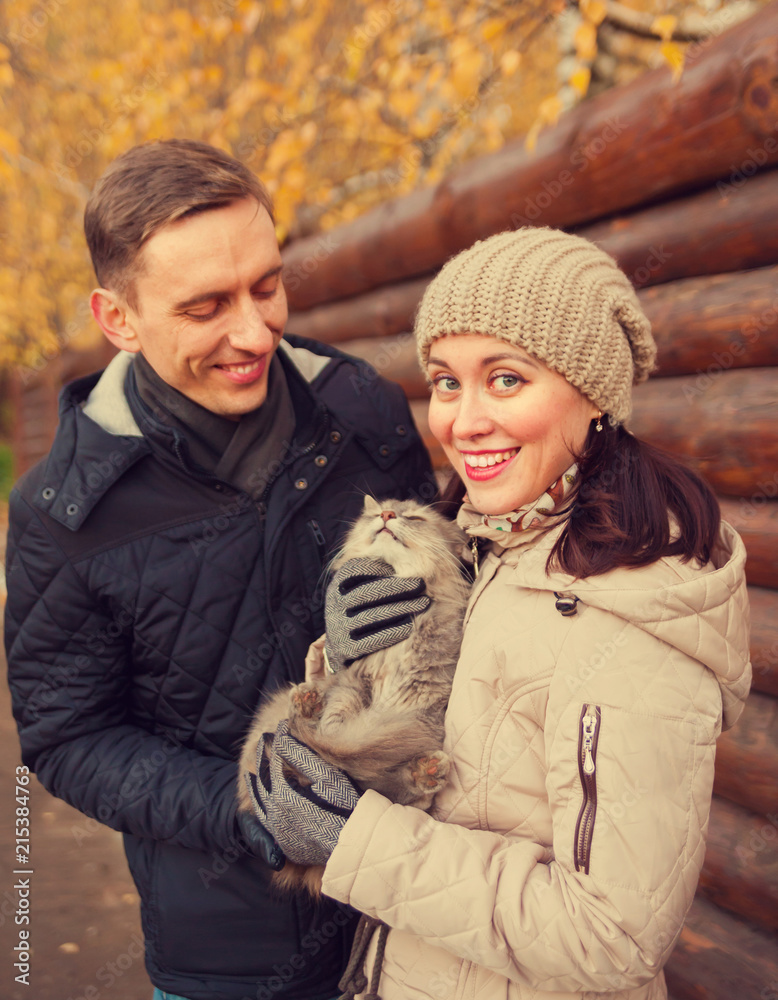 Fototapeta premium girl and guy with cat in autumn park