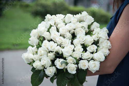 girl with bouquet of white roses flowers on dating in the city. photo