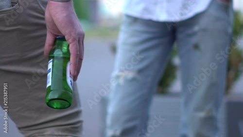 A man holding a beer whilst socialising photo