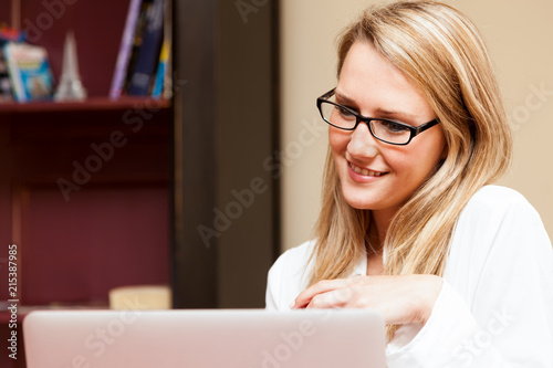 Принти на полотні Beautiful Young Woman Smiling at Laptop