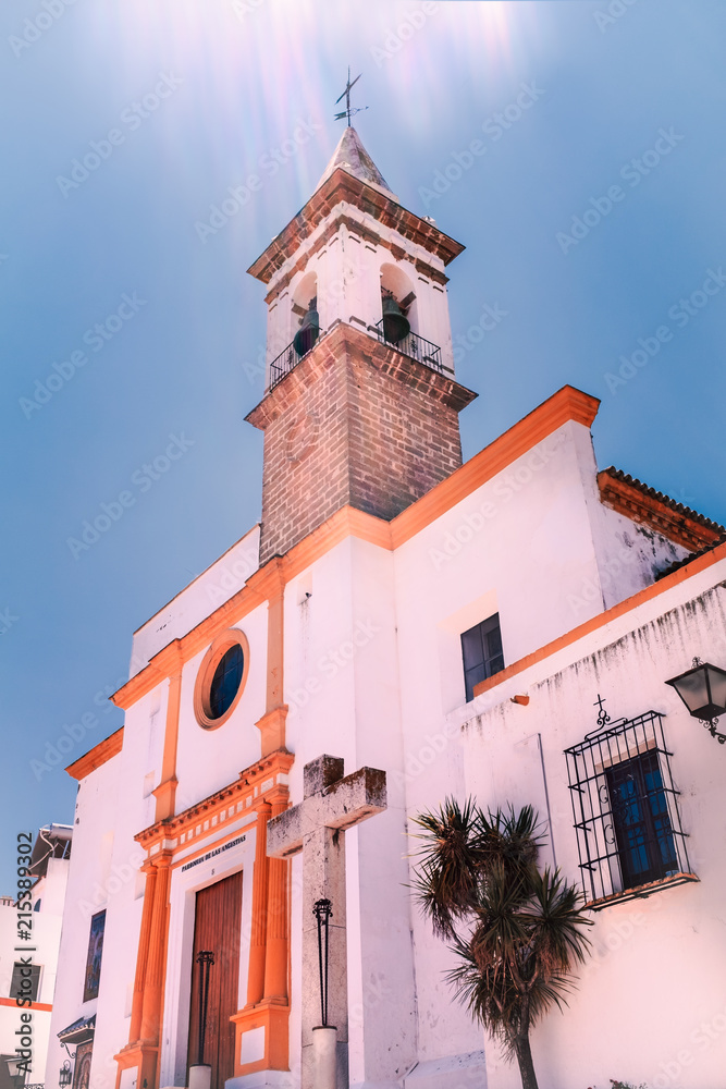 Sun glare beams against a blue sky summer day above the 16th century church Parroquia de Las Angustias  in Ayamonte, Huelva province, Andalusia, Spain.