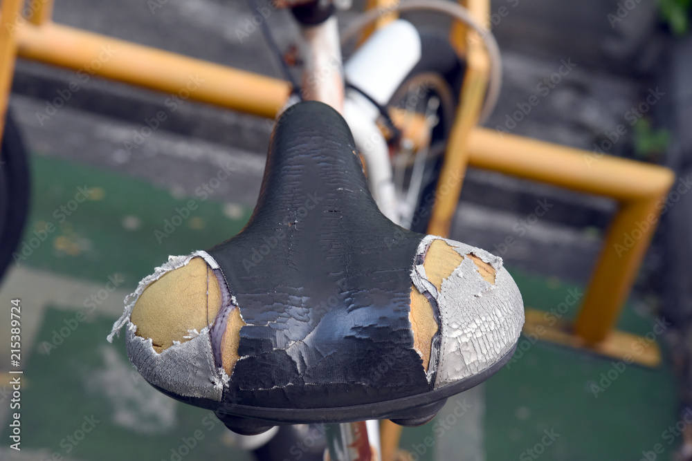 Old bicycle seat torn. Old and damage torn bicycle saddle seat with effect. Stock Photo Adobe