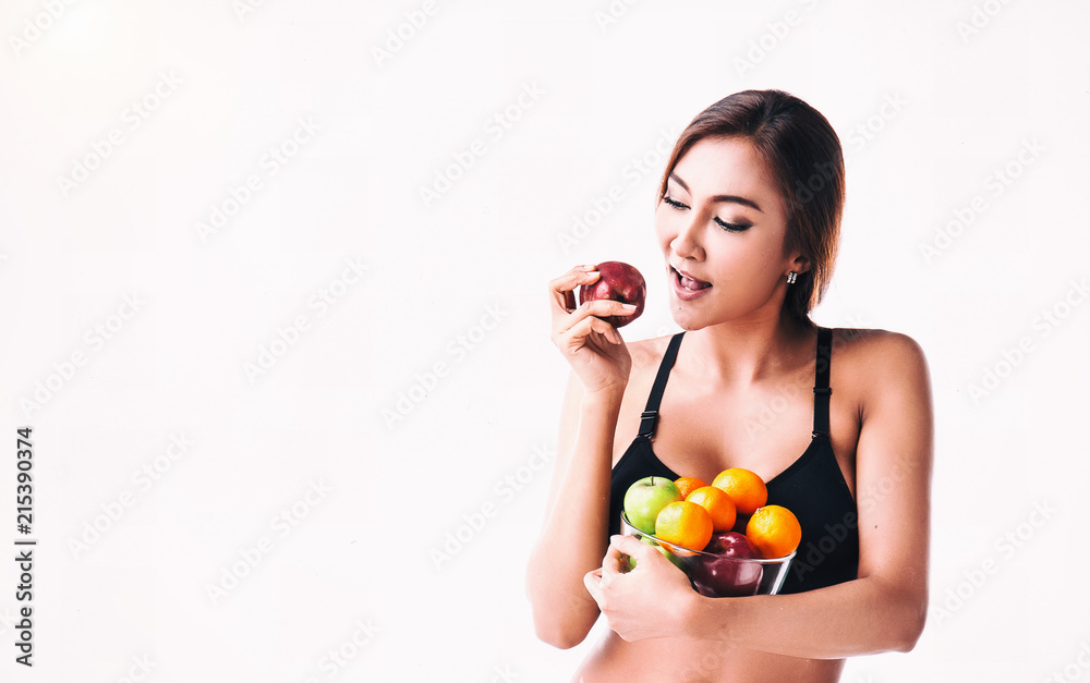 The beauty lady is eating red apple,hold glass bowl of fresh fruit in her arms, The beauty lady is eating red apple,hold glass bowl of fresh fruit in her arms,