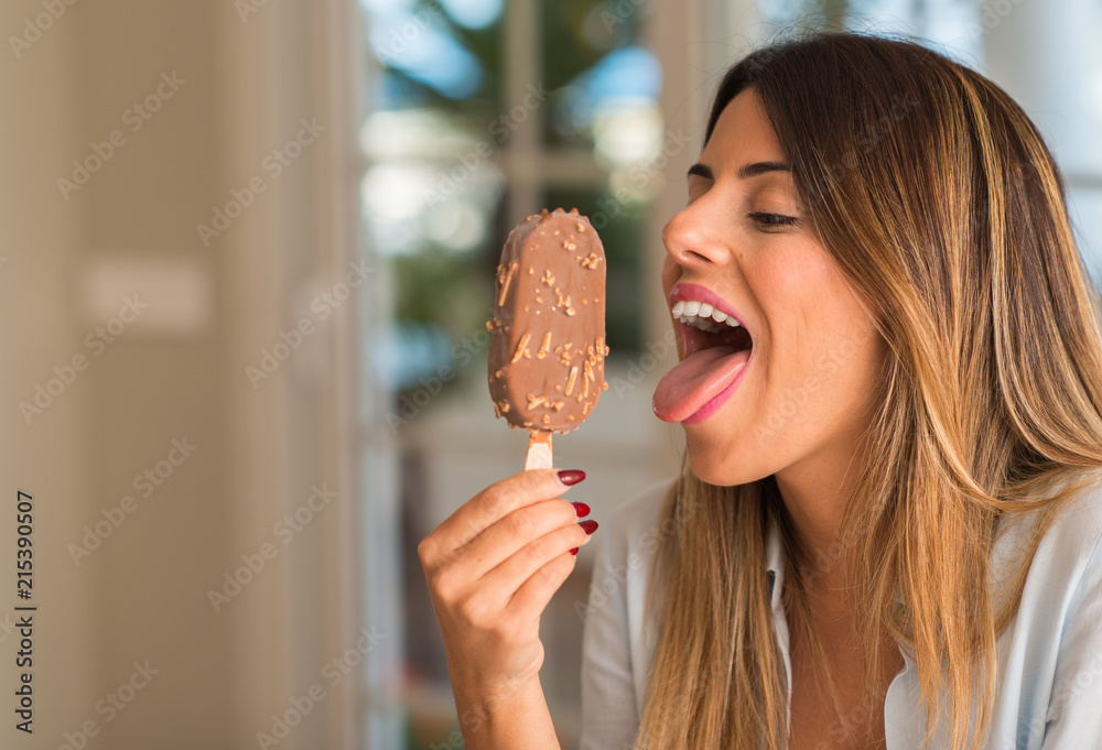 Beautiful young woman funny licking ice cream at home. Lifestyle concept. Beautiful young woman funny licking ice cream at home. Lifestyle concept.