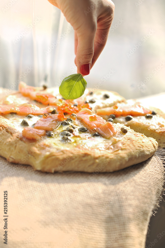 Pizza with salmon and basil and capers. Traditional Italian pastries. Copy space.