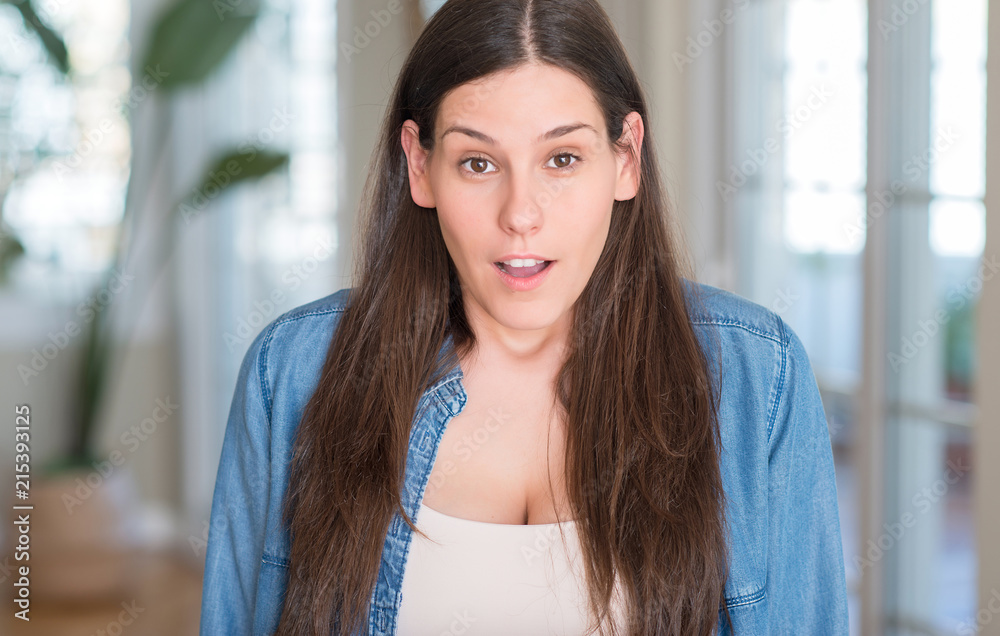 Young beautiful woman at home scared in shock with a surprise face, afraid and excited with fear expression